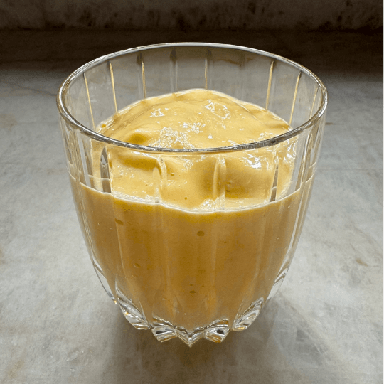 Mango lassi in a glass cup